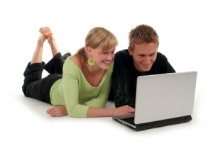 Pärchen schaut sich etwas auf einem Laptop an