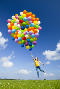 Frau springt mit Ballons