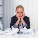 Frau im Büro mit zerknittertem Papier