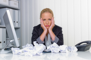 Frau im Büro mit zerknittertem Papier