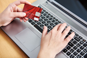 Frau an einem Laptop mit einer Kredit Karte