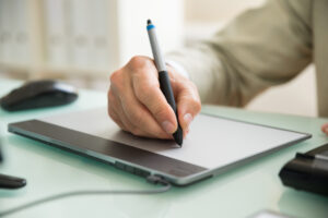 Businessmann, der auf Graphic Tablet schreibt