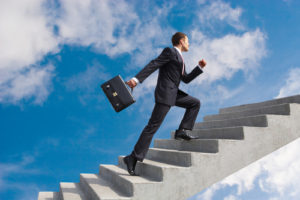 Image of confident businessman with briefcase walking upstairs