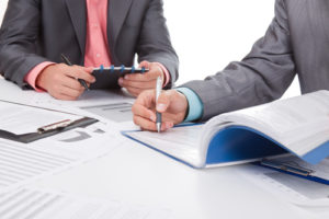 Business people in elegant suits sitting at desk handshake