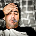 Drastisches Bild eines kranken Mannes im Bett mit Fieber