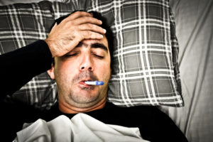 Drastisches Bild eines kranken Mannes im Bett mit Fieber