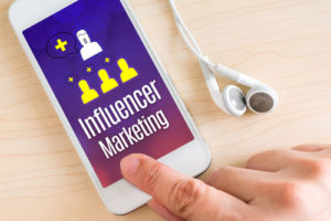 Hand-Touch-Smartphone und Ohrhörer mit Influencer Marketing