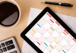 Tablet-PC, der Kalender auf Schirm mit einem Tasse Kaffee an einem Tag zeigt