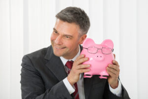 Businessmann hält Sparschwein in den Händen