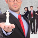 Anführer eines Businessteams mit dem weißen Schachkönig