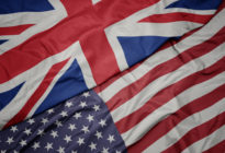 waving colorful flag of united states of america and national flag of great britain. macro