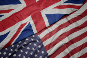 waving colorful flag of united states of america and national flag of great britain. macro