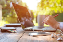 Person arbeitet an einem Laptop in der Natur