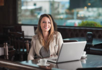 Schöne Frau im Café mit einem Laptop