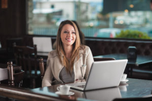 Schöne Frau im Café mit einem Laptop