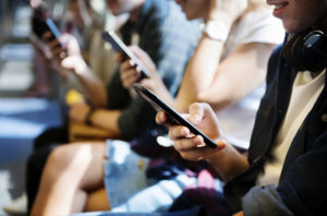 Gruppe junge erwachsene Freunde, die Smartphones in der U-Bahn verwenden