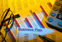 Businessplan mit Statistik, Brille und Taschenrechner