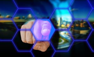 Der Zeigefinger einer Hand zeigt auf einen Blockchain-/Computervordergrund