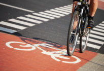 Ein Fahrradfahrer, dessen Beine nur zu sehen sind, fährt auf Radweg