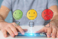 Kundenfeedback mit drei Emojis und Hände auf Smartphone