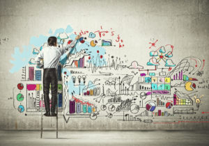 Junger Mann zeichnet auf Wand Start-up Strategie