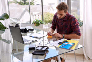 Junger Businessmann, der am Schreibtisch arbeitet