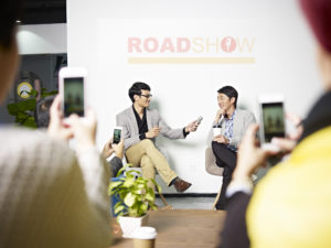 Junge, asiatische Unternehmer auf einer Roadshow