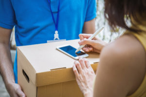 Frau, die Paket erhält und unterschreibt
