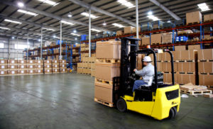 Logistik: Staplerfahrer mit Kartons