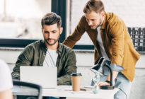 Zwei junge Männer am Laptop im Büro