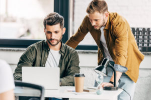 Zwei junge Männer am Laptop im Büro