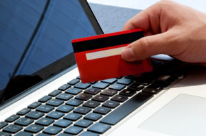 Online-Bezahlung: Hand mit Laptop und Kreditkarte