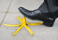 Businessmann tritt mit Schuh auf Bananenschale