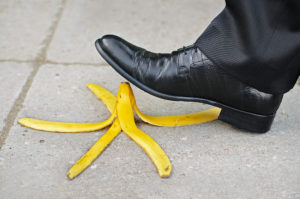 Businessmann tritt mit Schuh auf Bananenschale