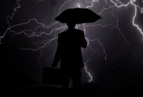 Businessmann mit Regenschirm im Gewitter