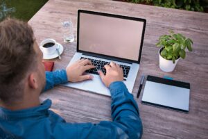 Junger Mann mit Laptop im Homeoffice