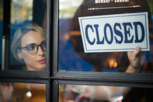 Shopbesitzerin hängt Closed-Schild auf