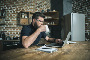 Junger Mann mit Laptop im Home-Office