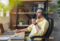 Homeoffice: Mann mit Headset und Laptop am Schreibtisch Zuhause