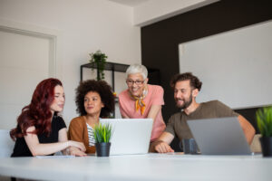 Junge Leute mit älterer Frau am Laptop