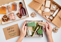 Hand fasst Werbeartikel in moderner Verpackung auf einem Tisch an
