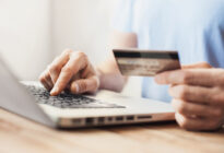 Mann kauft online mit Laptop und Kreditkarte ein