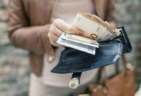 Frauenhände holen Euroscheine aus ihrem Portomonnaie