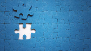 Blaues Puzzle, ein Puzzleteil liegt daneben