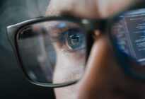 Gesicht eines Mannes mit Brille und Computerreflektion im Glas