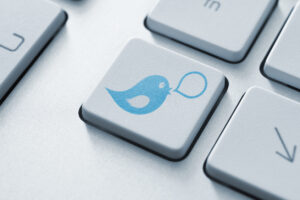 Blauer Twitter Vogel auf Computertastatur