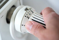 Energiekrise: Hand dreht Thermostat herunter