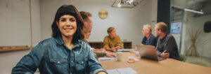 Junge Businessfrau im Meeting mit ihren Arbeitskollegen an einem Tisch