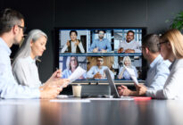 Businessleute in einem Büro sprechen über Videotelefonie mit anderen Kollegen