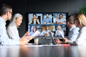 Businessleute in einem Büro sprechen über Videotelefonie mit anderen Kollegen
